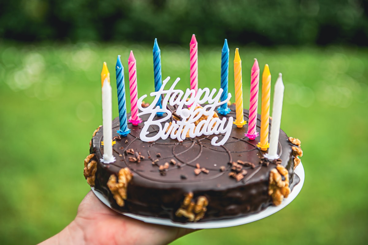 Birthday cake with lit candles and festive decorations