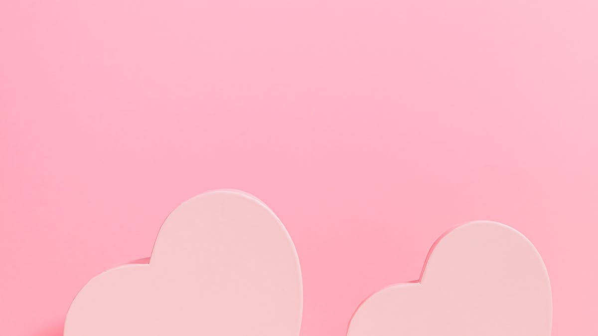 Soft pink hearts and decorative symbols on a pastel background