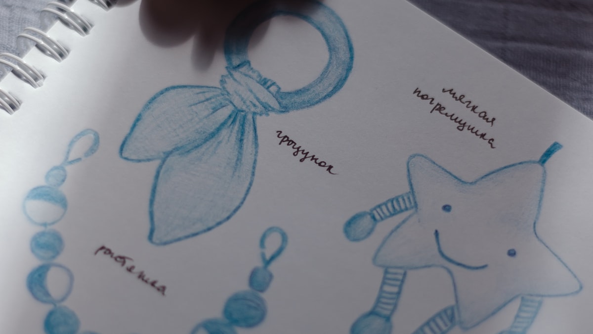 Handwritten baby name list in a notebook with a pen