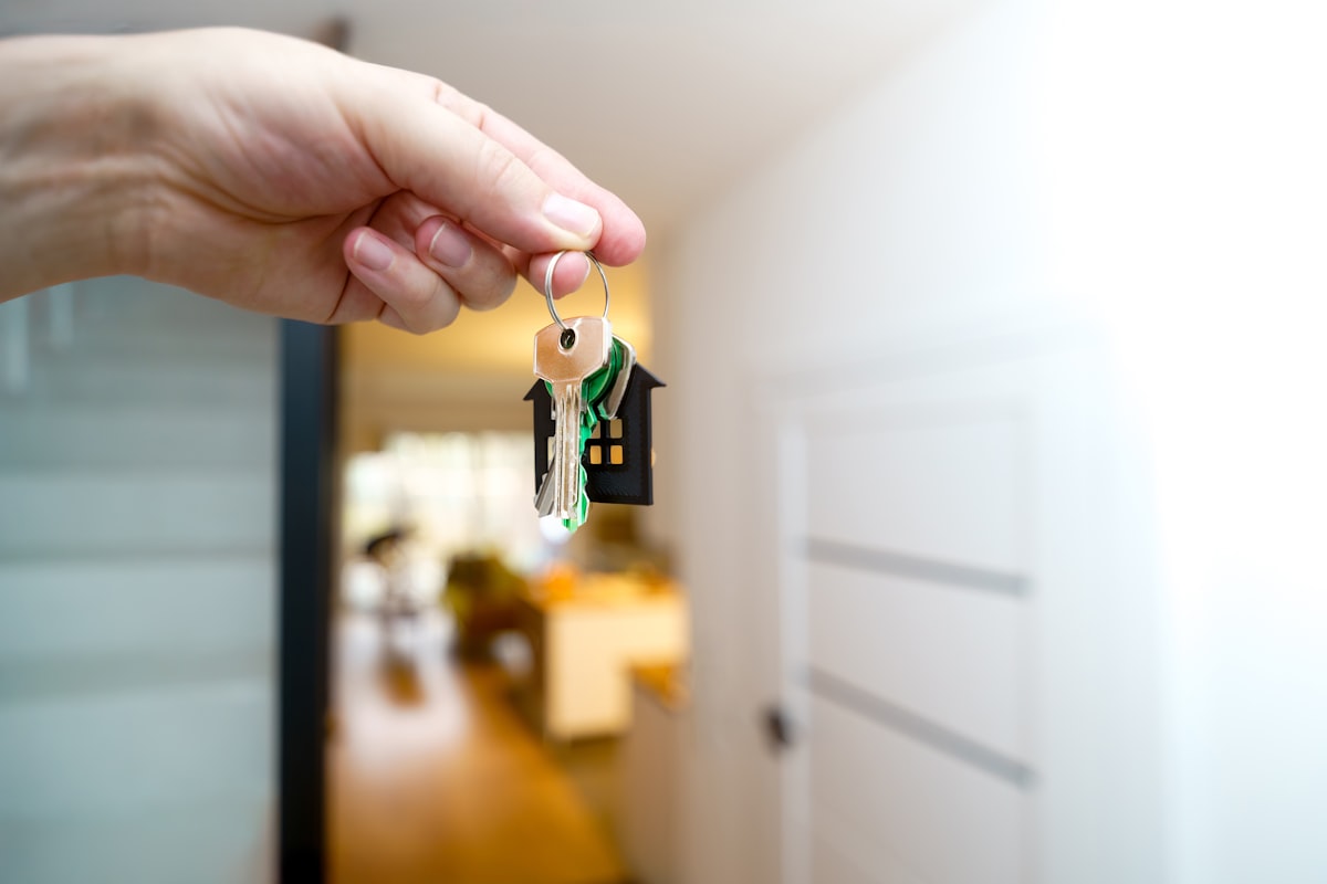 House keys resting on a mortgage contract with a calculator